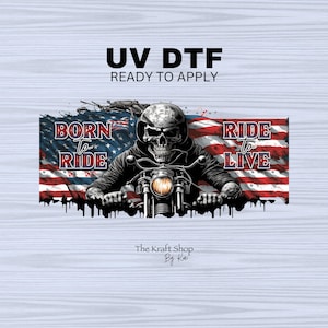May include: UV DTF ready to apply graphic featuring a skull biker riding a motorcycle in front of an American flag. The words "Born to Ride" and "Ride to Live" are displayed. The Kraft Shop By Kai logo is at the bottom.