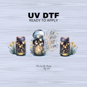 May include: A digital illustration featuring three mason jars filled with glowing lights and flowers. The text "UV DTF READY TO APPLY" is at the top, with "Let your light bloom" in a decorative script. The Kraft Shop By Kati is at the bottom.