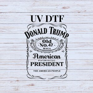 May include: Black and white graphic design on a wood background. The design is a parody of a whiskey label with the text "UV DTF DONALD TRUMP Old No. 47 MAGA American PATRIOTIC PRESIDENT THE AMERICAN PEOPLE".
