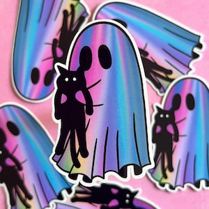 May include: A holographic sticker of a ghost holding a black cat. The ghost is a light blue, pink, and purple color. The cat is black with a white heart on its chest.