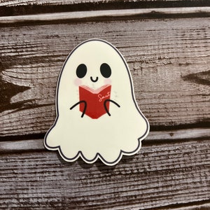 May include: A white ghost with a friendly face is reading a red book that says "Smut" on the cover.