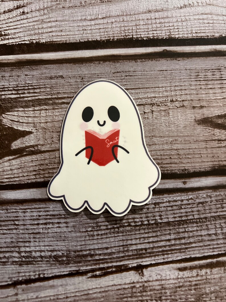 May include: A white ghost with a friendly face is reading a red book that says "Smut" on the cover.
