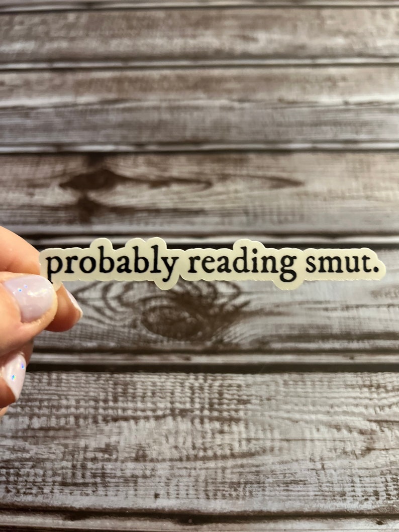 Puede incluir: Una pegatina blanca con texto negro que dice "probably reading smut."
