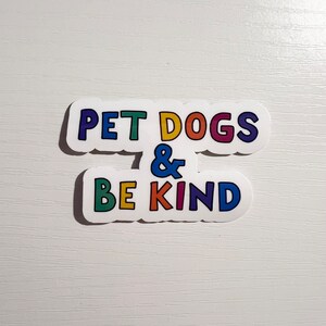 May include: A white sticker with the text "Pet Dogs & Be Kind" in rainbow colors.