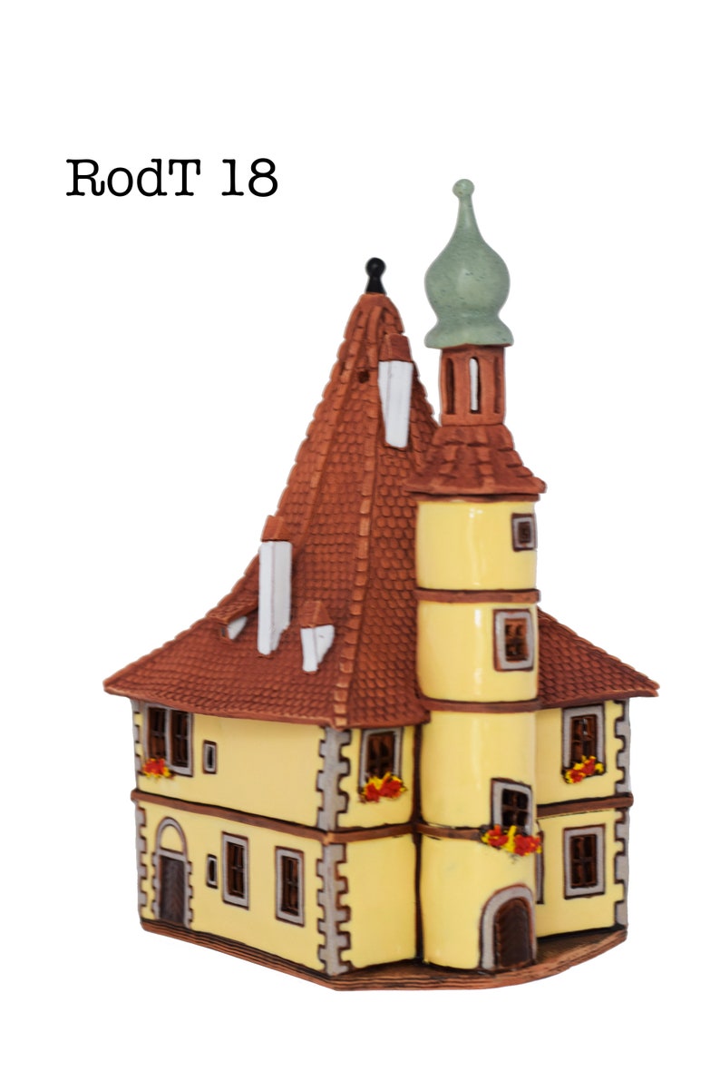 May include: A yellow ceramic building with a brown roof and a green spire. The building has windows and a door. The text "RodT 18" is visible on the image.