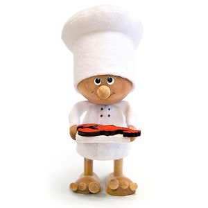 May include: A wooden figurine of a chef wearing a white chef's hat and holding a red lobster on a white plate.
