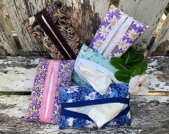 Può includere: Cinque copri scatola di fazzoletti in tessuto con diversi motivi floreali. Le copertine sono in tessuto di cotone e hanno una chiusura a zip. Le copertine sono di vari colori, tra cui viola, blu, marrone e bianco.