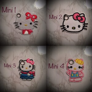 May include: Four embroidered Hello Kitty keychains with different outfits. The keychains are labeled "Mini 1", "Mini 2", "Mini 3", and "Mini 4".