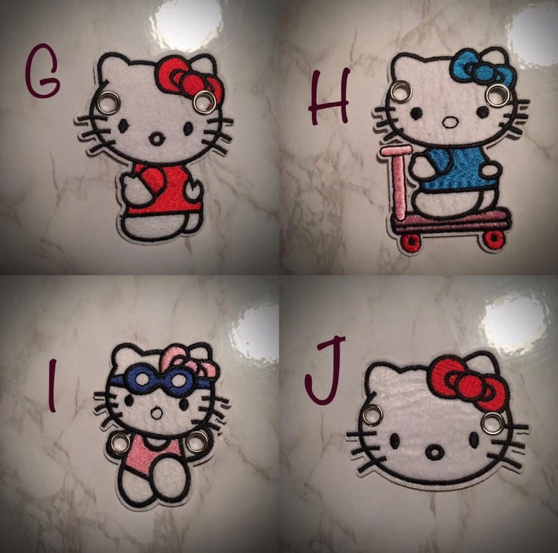 May include: Four embroidered iron-on patches featuring Hello Kitty in different outfits. The patches are white with black outlines and feature different colored accents. The first patch shows Hello Kitty wearing a red shirt, the second shows Hello Kitty riding a scooter, the third shows Hello Kitty wearing a swimsuit and goggles, and the fourth shows Hello Kitty with a red bow.