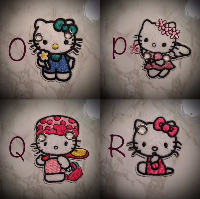 May include: Four embroidered Hello Kitty patches with different outfits. The patches are white with black outlines and feature Hello Kitty with different accessories. The patches are labeled with the letters O, P, Q, and R.
