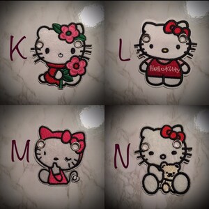 May include: Four embroidered patches featuring Hello Kitty in different poses. The patches are white with red and black details. The first patch shows Hello Kitty holding a flower. The second patch shows Hello Kitty wearing a red shirt with the text "Hello Kitty". The third patch shows Hello Kitty with her eyes closed. The fourth patch shows Hello Kitty holding a teddy bear.