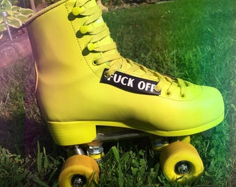 May include: Yellow roller skates with black wheels and a black "F*CK OFF" patch on the side.