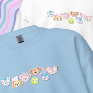 May include: A light blue sweatshirt with a row of cartoon animal faces printed on the front. The animals include a bear, a rabbit, a cat, and a dog. The sweatshirt has a crew neck and long sleeves.