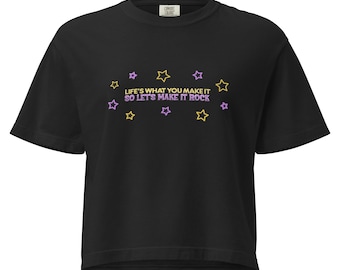 May include: Black t-shirt with the text "LIFE'S WHAT YOU MAKE IT SO LET'S MAKE IT ROCK" in purple and yellow. The design includes star shapes in yellow and purple. The shirt has a crew neck and short sleeves.