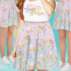 May include: A purple and white skater skirt with a pattern of cartoon animal faces. The skirt has a light pink background with a white polka dot pattern. The animal faces are all different colors and have a variety of expressions.