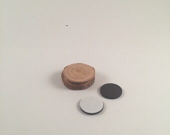 May include: A wooden round slice with a natural bark edge, a black round sticker, and a white round sticker.
