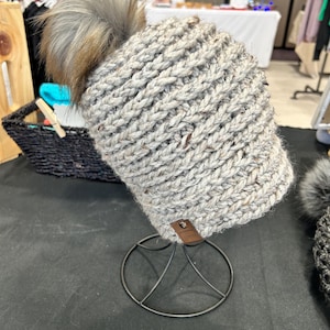 Women’s crochet hat with faux fur pom.  Great neutral grey crochet hat with a luxe fuzzy pom.  Great for gift-giving and READY TO SHIP!