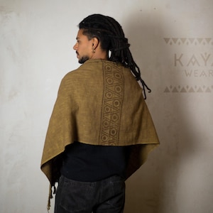 May include: A person wearing a brown shawl with a geometric pattern. The shawl is made of a soft, woven fabric. The text "KAYA WEAR" is visible in the top right corner of the image.