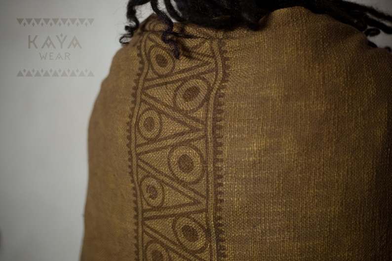 May include: A brown linen scarf with a dark brown geometric pattern. The pattern features circles and triangles.