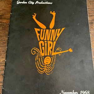 以下が含まれることがあります： ガーデンシティプロダクションズのミュージカル「ファニーガール」の黒とオレンジのプログラム。プログラムには、黄色のドレスを着て足を上げた女性のイラストが描かれている。プログラムの下部には「1968年11月」の日付が印刷されている。