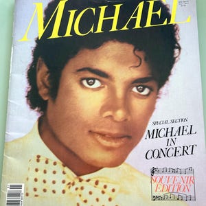 May include: A vintage magazine cover featuring Michael Jackson. The title "MICHAEL" is in large yellow letters. The cover includes the text "SPECIAL SECTION MICHAEL IN CONCERT" and "SOUVENIR EDITION". Michael Jackson is wearing a bow tie.