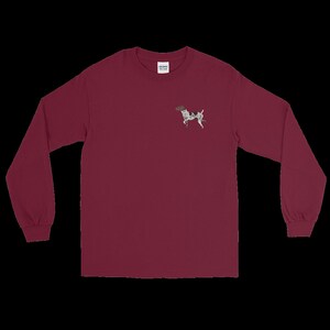 May include: A maroon long-sleeve t-shirt with a small embroidered image of a black and white dog on the left chest.