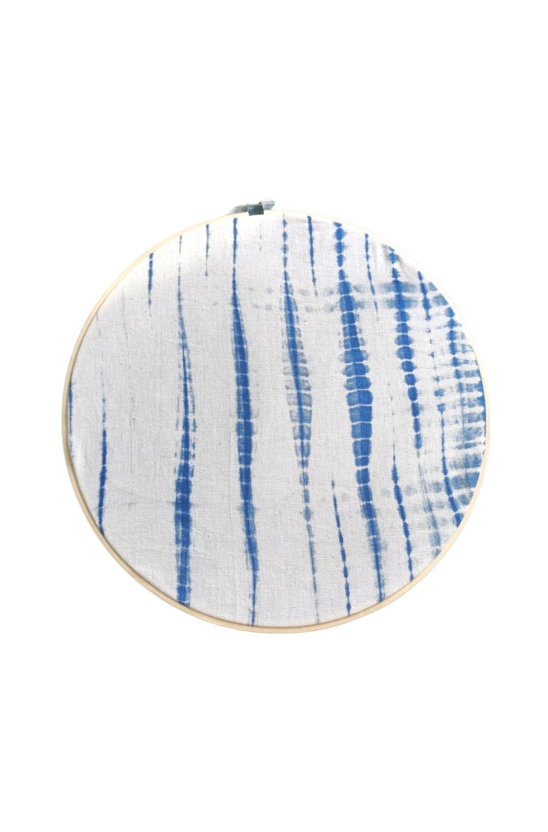 May include: A round embroidery hoop with a white fabric background and blue tie-dye pattern.