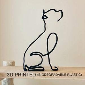 May include: A 3D printed black dog sculpture in a sitting position. The sculpture is made of biodegradable plastic and has a simple, minimalist design.