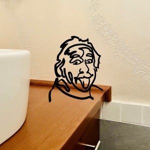 Puede incluir: Un dibujo en blanco y negro de una persona con la lengua fuera, dibujado sobre una superficie de madera.