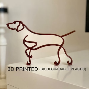 May include: A 3D printed dog sculpture made of biodegradable plastic. The sculpture is a brown outline of a dog standing on all four legs. The sculpture is on a white surface. The text "3D PRINTED (BIODEGRADABLE PLASTIC)" is below the sculpture.
