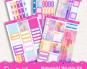 Op de afbeelding: Printbare planner stickers voor een Hobonichi Cousin of Weekplanner. De stickers hebben een aquarelontwerp in de kleuren roze, blauw, geel en paars. De stickers bevatten vakjes, cirkels en dagen van de week.