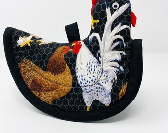 Puede incluir: Manopla de cocina negra y blanca con un gallo, una gallina y pollitos sobre un fondo negro con un patrón de alambre de pollo blanco.