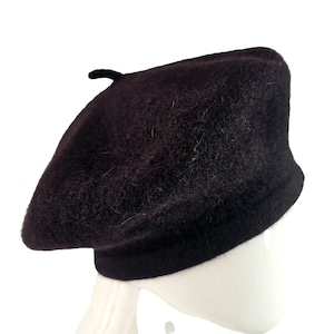 May include: A black beret made of wool. The beret has a soft, fuzzy texture.