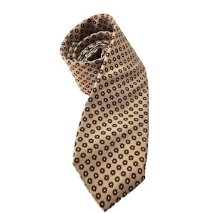 Puede incluir: Una corbata de seda de color beige con un patrón repetitivo de pequeñas flores marrones.