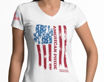 May include: White V-neck t-shirt with a distressed American flag design. The flag is red, white, and blue with the words "American Pride" and "Ruthless Americans" printed on it.