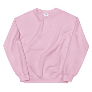 May include: A pink crewneck sweatshirt with the text "I shall not want" embroidered in red on the front.