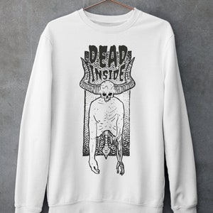 Pode incluir: Camisola branca com uma estampa gr&aacute;fica em preto e branco de um esqueleto com chifres e o texto "DEAD INSIDE".