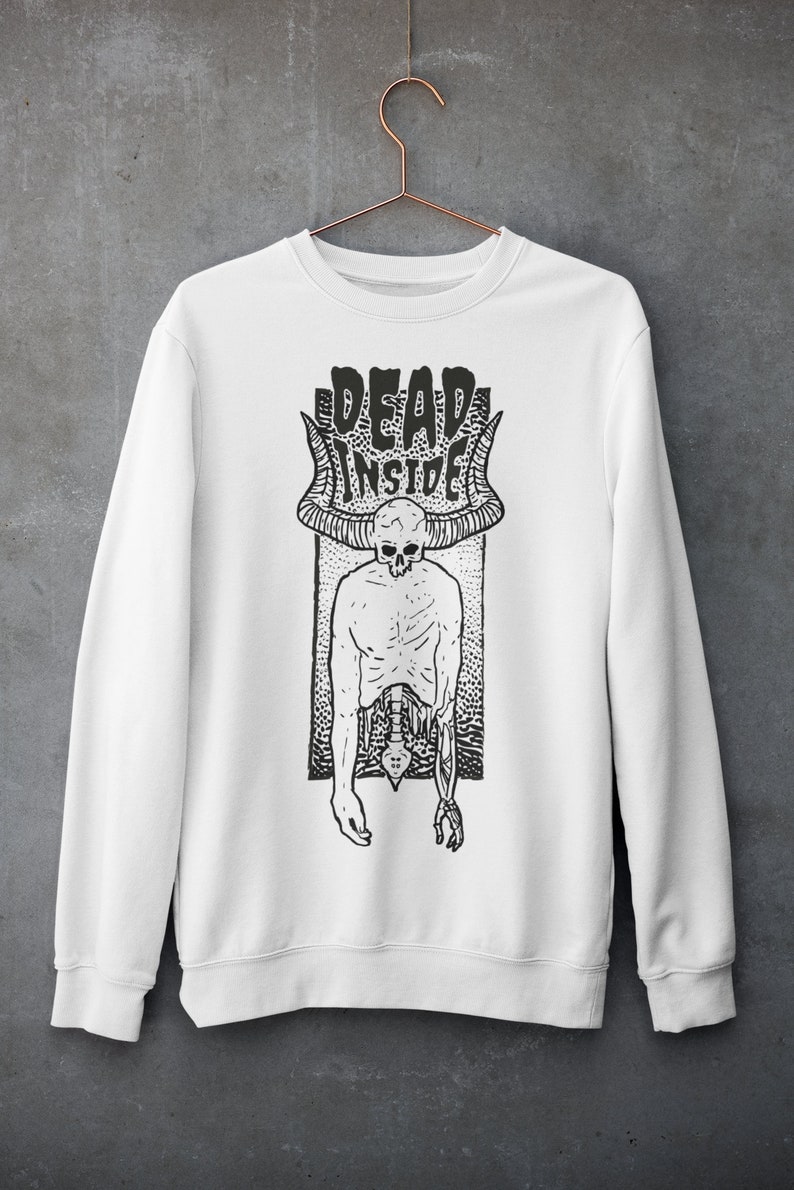 Pode incluir: Camisola branca com uma estampa gr&aacute;fica em preto e branco de um esqueleto com chifres e o texto "DEAD INSIDE".