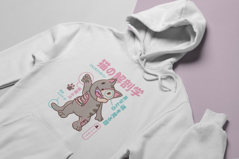 May include: White hoodie featuring a cartoon cat illustration. The cat is dissected with Japanese text that reads "Cat Anatomy" and "See your soul".