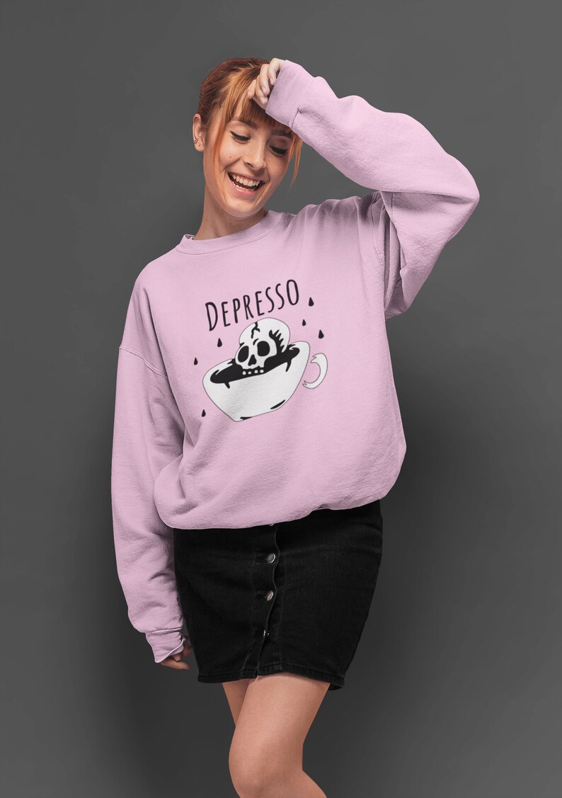 May include: A pink sweatshirt with the text "DEPRESSO" and a black and white illustration of a skull in a coffee cup.