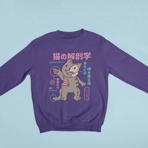 May include: Purple sweatshirt featuring a cartoon cat anatomy illustration. The text on the shirt reads "猫の解剖学" and "あなたの猫を見る目".