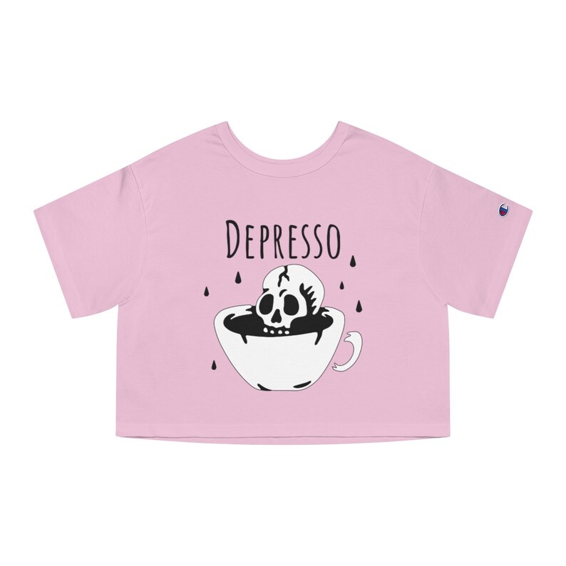 May include: Pink cropped t-shirt with a black and white illustration of a skull in a coffee cup. The text "DEPRESSO" is printed above the illustration.