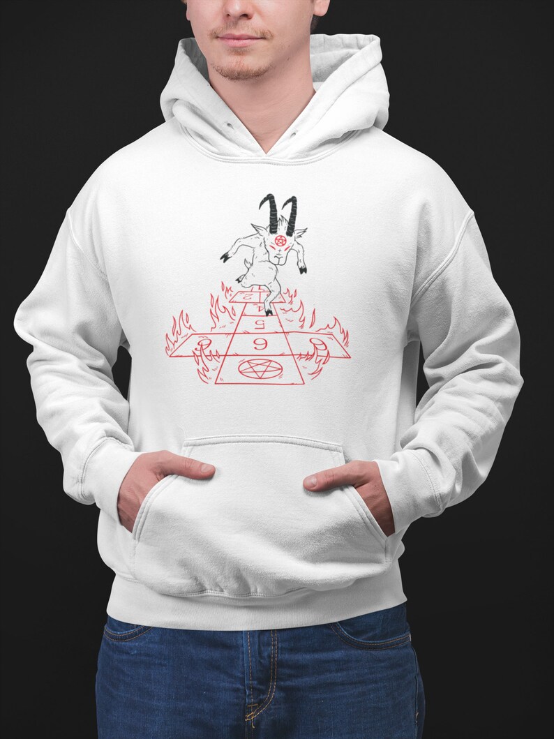 Peut inclure: Sweat-shirt &agrave; capuche blanc avec une illustration en noir et blanc d'une ch&egrave;vre avec des cornes et un pentagramme sur le front. La ch&egrave;vre se tient sur un damier rouge et blanc avec des flammes sur les c&ocirc;t&eacute;s. Le damier porte les chiffres 1, 5 et 9.