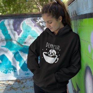 May include: Black hoodie with a white skull and crossbones graphic and the text "DEPRESSO" printed on the front.