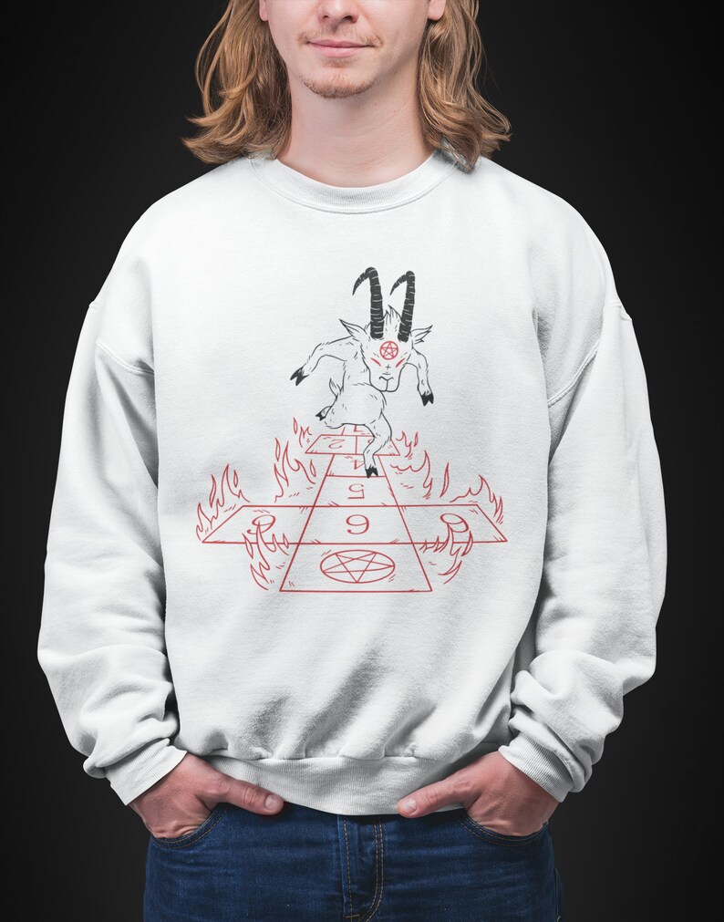 Peut inclure: Sweat-shirt blanc avec un motif noir et rouge d'une ch&egrave;vre avec des cornes et un pentagramme sur le front, marchant sur un jeu de marelle enflamm&eacute; avec les chiffres 1, 2, 3, 4, 5, 6, 7, 8 et 9.