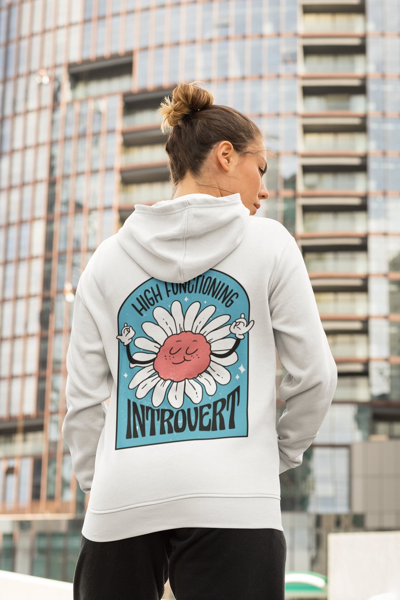 May include: White hooded sweatshirt with a blue and white graphic of a daisy with the text "High Functioning Introvert".