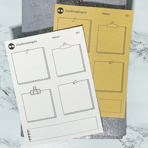 May include: A sheet of white memo stickers with black outlines. The stickers feature different designs, including a clipboard, a push pin, and a spiral binding. The stickers are labeled "Memos" and "021".