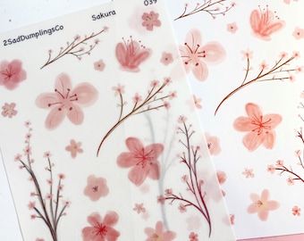 Pode incluir: Duas folhas de papel adesivo transparente com desenhos de flores de cerejeira rosa em aquarela. Os adesivos são etiquetados como "Sakura 039" e "2SadDumplingsCo".