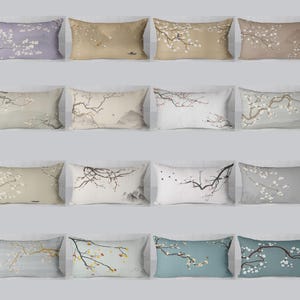 May include: A selection of rectangular cushions with floral branch patterns. The cushions display diverse background hues, such as lavender, beige, and grey, with white and yellow blossoms. The designs have an Asian-inspired aesthetic.