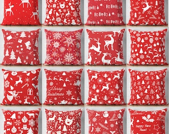 May include: A collection of sixteen square throw pillows featuring a red background with various white holiday-themed patterns including reindeer, snowflakes, Christmas trees, stockings, gifts, and text such as Ho Ho Ho and Merry Christmas.